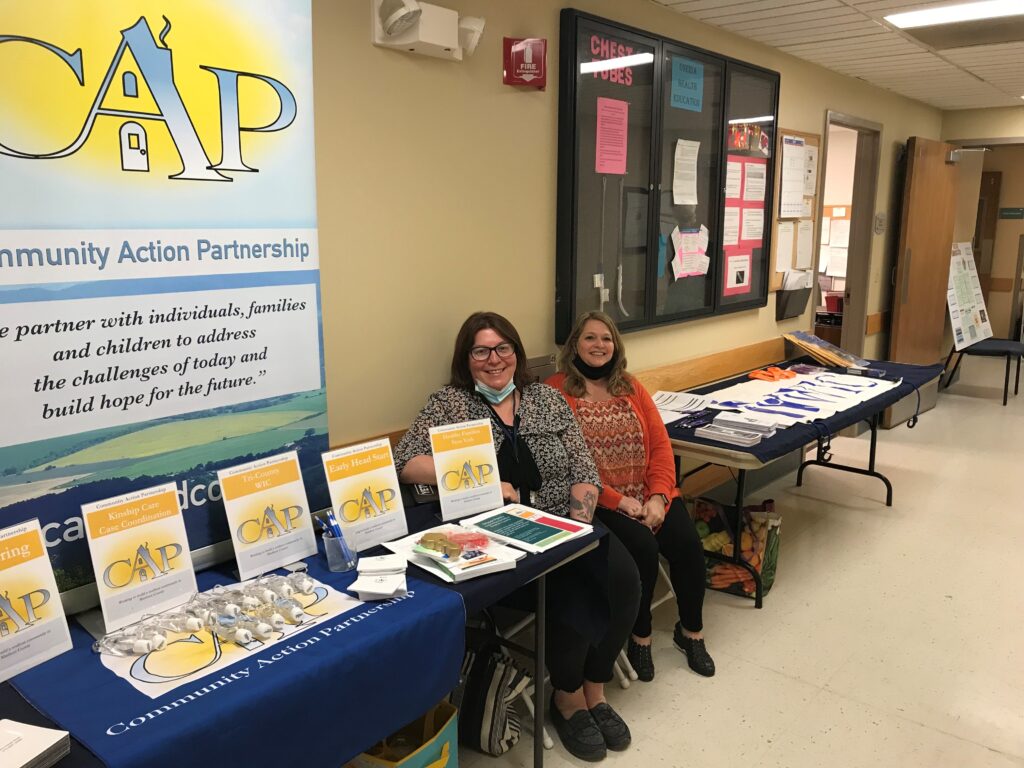 two women sitting next to educational exhibit