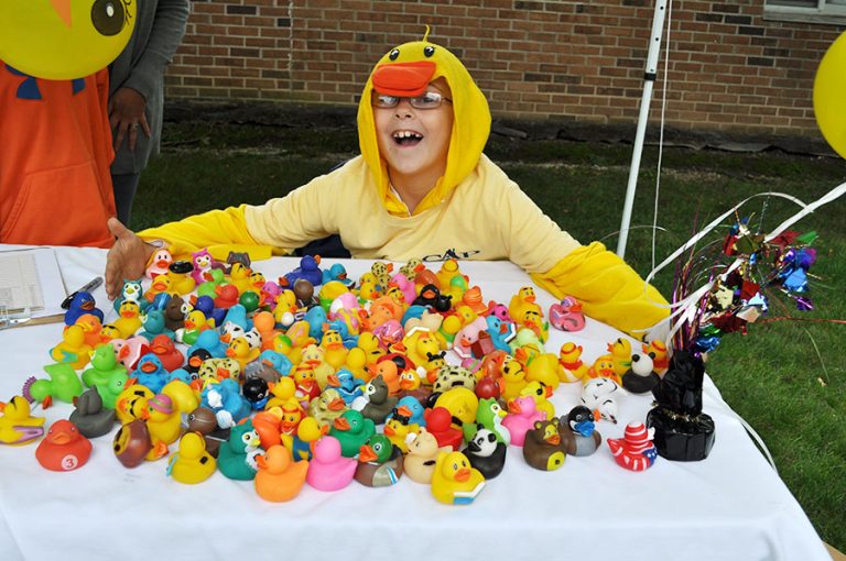 child in duck costume posing with rubber ducks