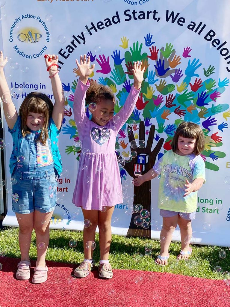 three little girls smiling at a cap event