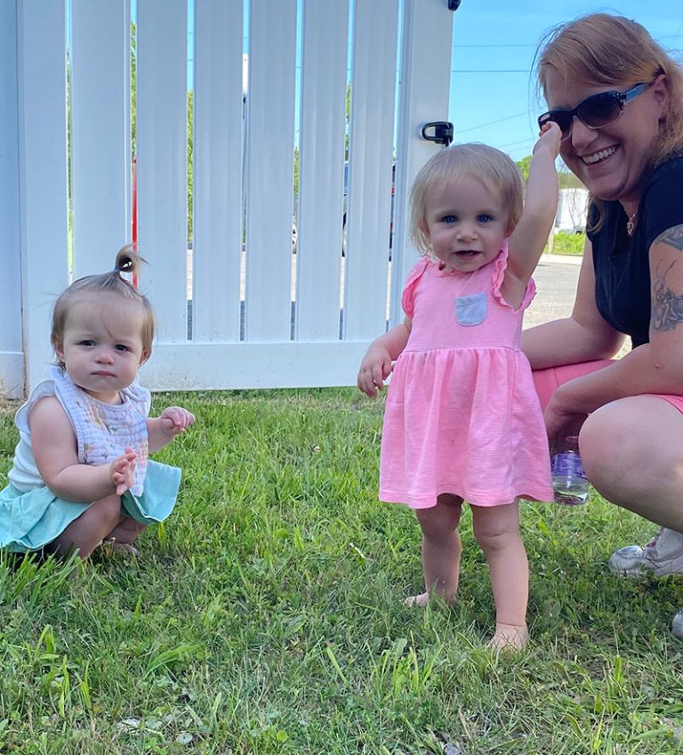 two infant girls playing in the grass