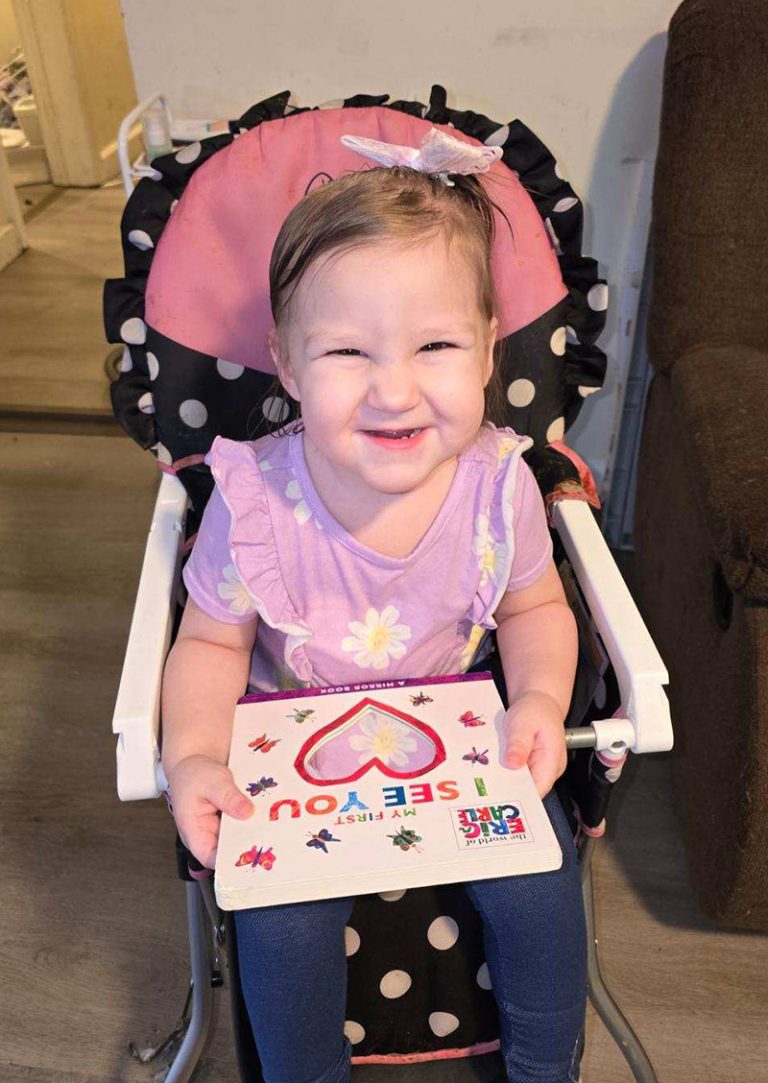 smiling infant girl with book